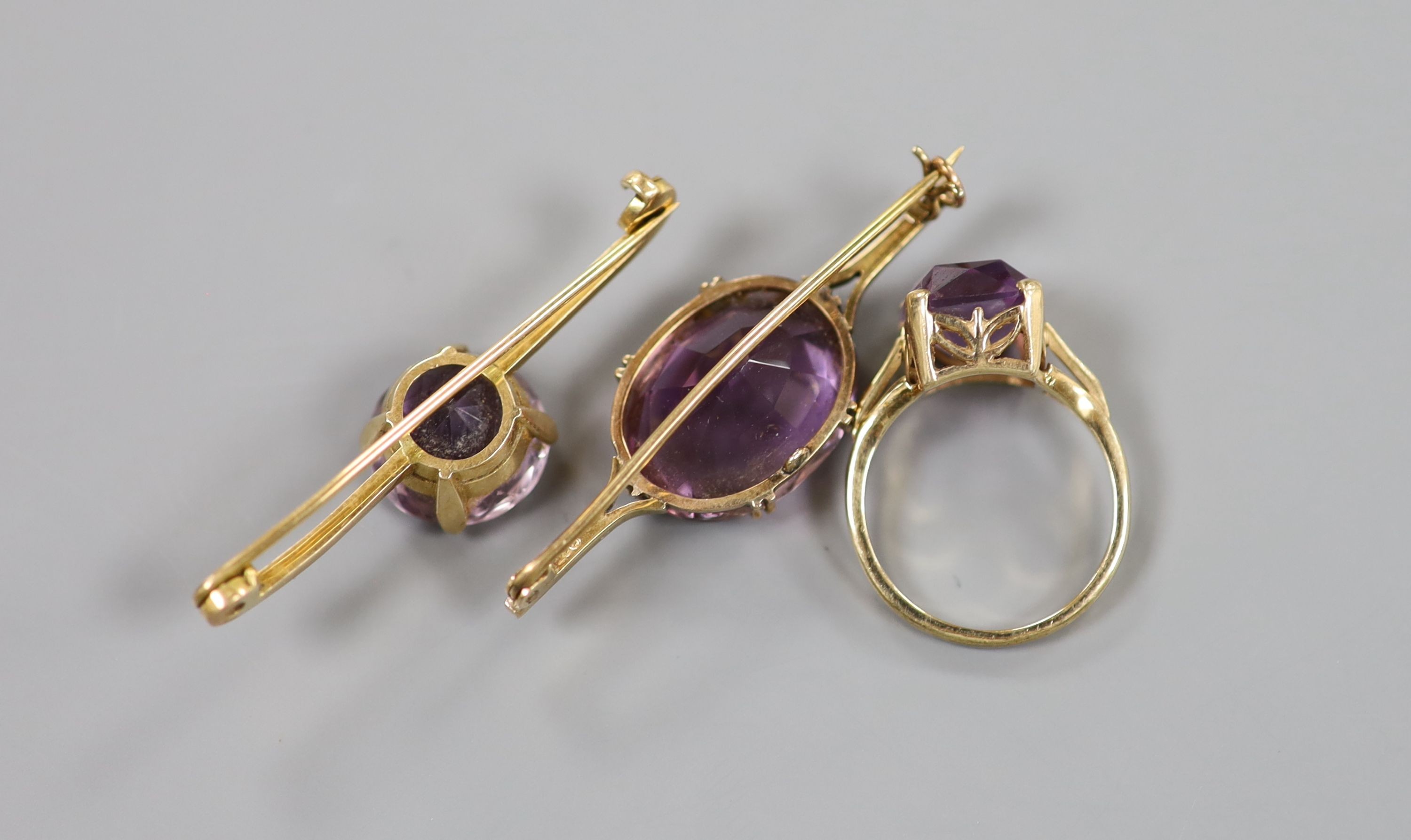 A modern 9ct gold and amethyst set dress ring and two yellow metal and amethyst set bar brooches, one stamped 9ct, gross weight 15.3 grams.